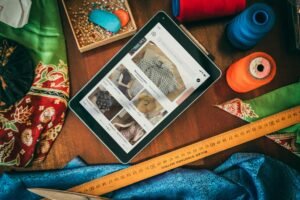 Flat lay of a tablet with sewing supplies, showcasing a digital platform for fabric and patterns.
